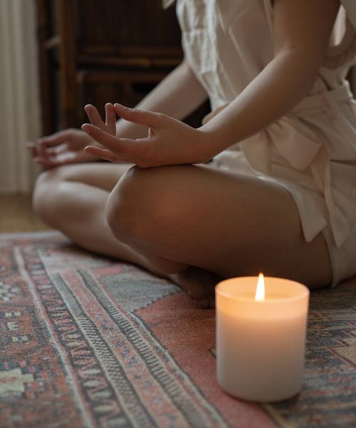 Woman in a calming yoga pose, bathed in soft turquoise light.